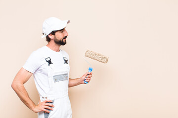 Wall Mural - young painter bearded man painting a wall with a apint roller