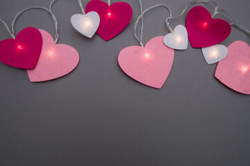 hearts in the form of garlands lie on a gray background.