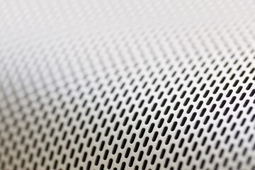 Abstract background macro shot of shiny aluminium metal sheet with holes