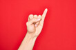 © Krakenimages.com - Hand of caucasian young man showing fingers over isolated red background showing little finger as pinky promise commitment, number one