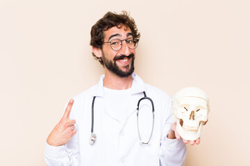 Wall Mural - young physician man and a human skull model.