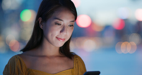 Sticker - Woman use of cellphone over city night view