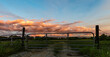© jackienix - Metal gate with bright sunset clouds