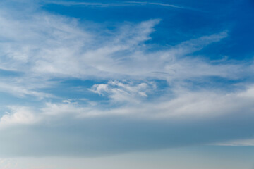 Wall Mural - landscape of stretched clouds of white light against a blue sky