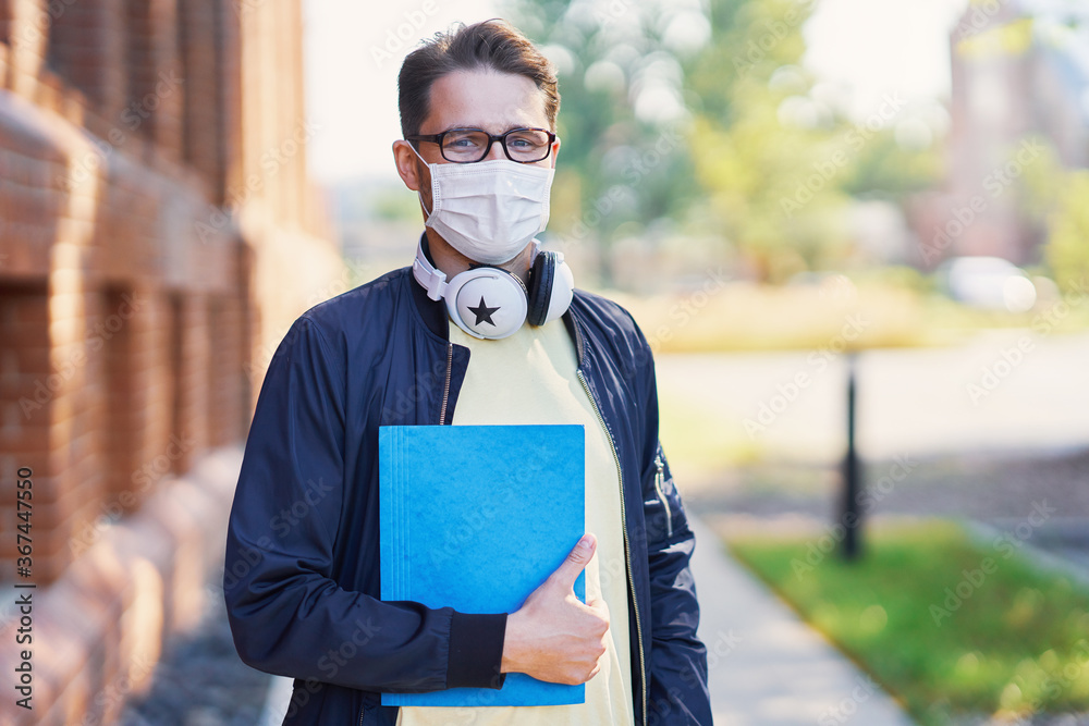 Male student in the campus wearing maskk due to coronavirus pandemic - obrazy, fototapety, plakaty 