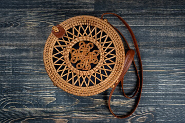 Modern stylish round straw bag on the wooden background