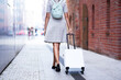 © Kalim - Tourist walking with suitcase through the city