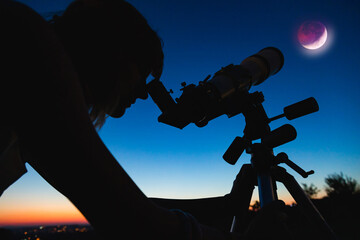 Wall Mural - silhouette of a woman and telescope with twilight sky.