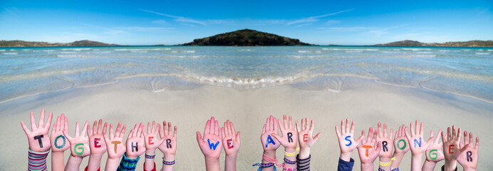 Wall Mural - Children Hands Building Colorful Word Together We Are Stronger. Ocean And Beach As Background