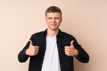 Young handsome man giving a thumbs up gesture