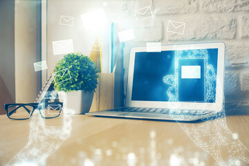 Desktop computer background in office and flying envelops hologram drawing. Multi exposure. Electronic mail concept.