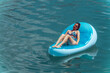 © Zamrznuti tonovi - Young woman relaxing at the beach while sunbathing on a floating mattress