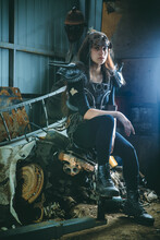 Post Apocalyptic Woman Warrior In Armor Is Sitting On The Rusty Engine.