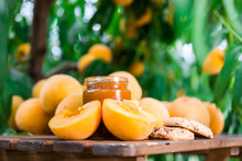 Ripe Appetizing Yellow Peaches And Marmalade On Table In Garden