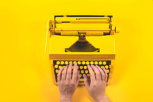 Yellow Bright Typewriter On A Yellow Background. Creativity Concept