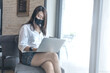 © monster_code - Businesswoman wearing medical facial mask working alone on laptop at cafe after coronavirus outbreak. Female freelancer using computer and remote work. New Normal, Social Distancing concept