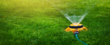 Garden Equipment - Water Sprinkler Watering Lawn At Home Backyard. Banner Copy Space
