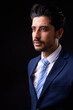 © Ranta Images - Young handsome bearded Persian businessman against black background