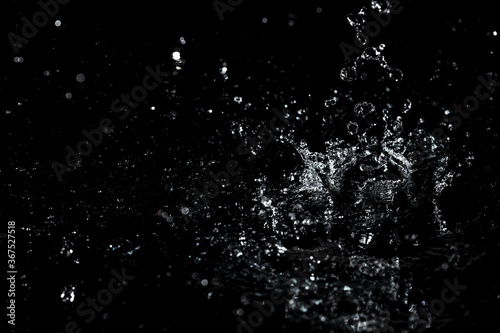 Cuadros en Lienzo Splashes and drops of water are on a black background.