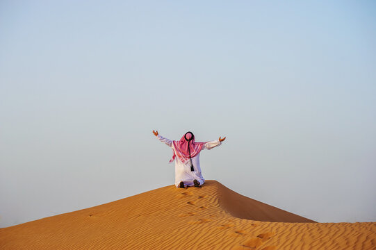 Portrait of Arabic man on a middle of yellow desert.