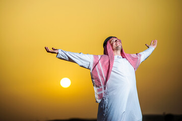 Wall Mural - Portrait of Arabic man on a middle of yellow desert.