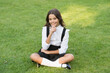 © be free - thoughtful pupil child wear uniform. back to school. happy childrens day. small girl outdoor. fashion for kids. spring sunny day. just having rest. cheerful schoolgirl relax on green grass