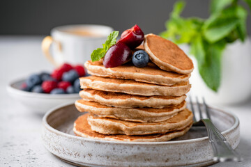 Wall Mural - Vegan gluten free buckwheat pancakes with berries on a plate. Healthy pancakes