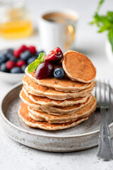 Wall Mural - Vegan oat pancakes with berries on plate. Gluten free pancakes stack