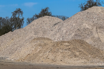 Wall Mural - View into a gravel pit with piles of sand and some tire tracks