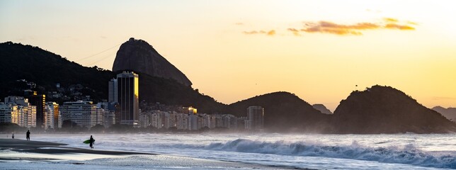 Wall Mural - Panoramic view of a wavy sea with hills on the background at sunset - Brazilian Content