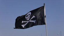 The Pirate Flag On The Background Of Blue Sky