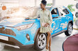 © alfa27 - black woman standing next to new blue car, attractive lady in dress posing at camera, make purchase in dealership