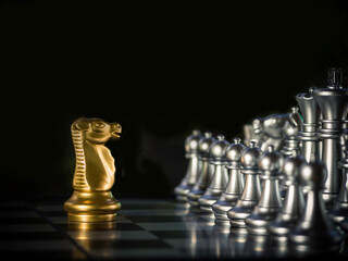 Wall Mural - Golden chess knight stands in front of competitors(silver chess).Leadership and courage.Purposeful,commercial and competitive business strategy.Business leader,confrontation solve problems concept.