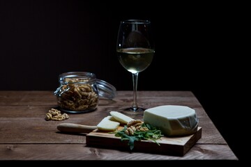 Poster - Wooden board with cheese near a wineglass