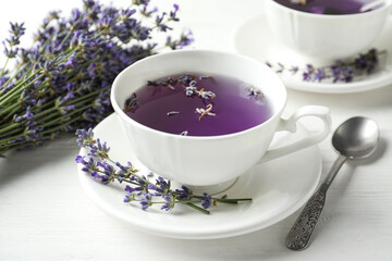 Fresh delicious tea with lavender and beautiful flowers on white wooden table