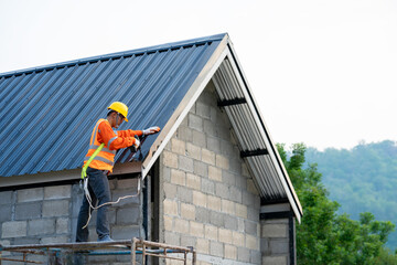 Poster - Construction worker wearing safety harness are install new roof,Concept of residential building under construction.