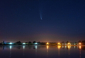 Wall Mural - Comet NEOWISE in the night sky over the river, with the Milky Way and a tourist with a tent
