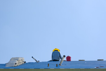 Male worker sitting for rest. team service install roof tiles second floor high building dangerous place