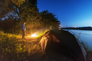Wall Mural - comet neowise in the night sky over the river, with the milky way and a tourist with a tent