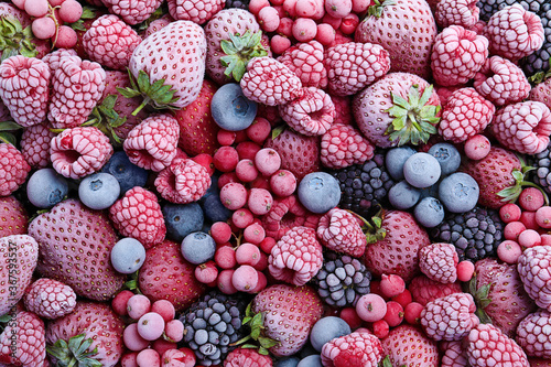 Fotografía Mix of different frozen berries as background, top view