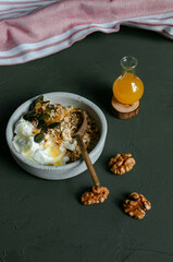 Healthy breakfast - greek yoghurt with cereal, nuts, seeds and honey. 