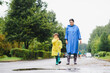 © Serhii - Mother and child, boy, playing in the rain, wearing boots and raincoats