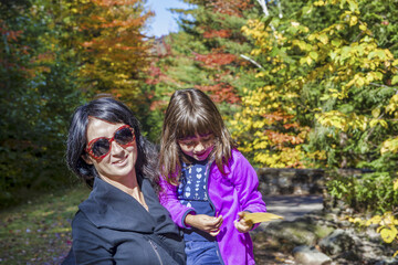 Canvas Print - Happy woman embracing her daughter on a beautoful foliage excursion