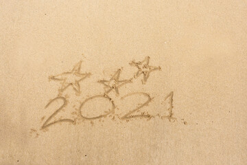 Wall Mural - Hand written sign on a yellow warm sand three stars and 2021 year