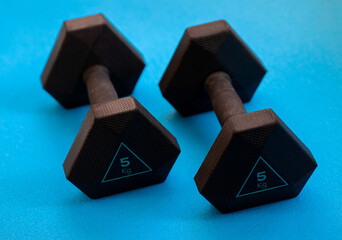 Two black weights 5 kg on the blue background