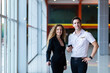 © NVB Stocker - Young handsome man pilot in uniform standing at airport with beautiful young business woman