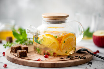 fruit tea with orange and apple in a glass teapot