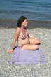 pregnant woman sitting and sunbathing on the beach,look side