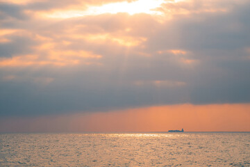 Wall Mural - Beautiful ocean sunset over Indian ocean. Container cargo ship silhouette far at the horizon line.