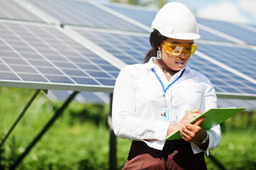 African american technician check the maintenance of the solar panels. Black woman engineer at solar station.